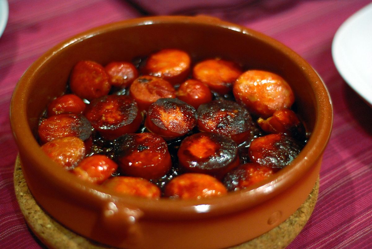 Cazuela de barro con rodajas de chorizo cocinado a la sidra